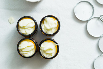 cosmetic lotion cream diy do it yourself ingredients creamer arrangement on white textile cloth top view