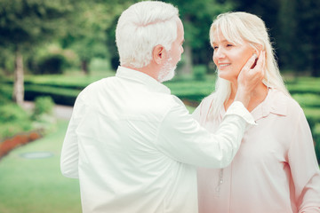 Delighted nice man touching his wifes cheek