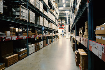Large wharehouse with rows of shelves and goods boxes.