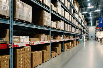 Large wharehouse with rows of shelves and goods boxes.