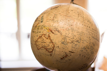 An antique globe in front of a bright window.