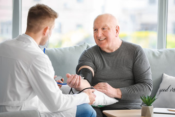Doctor examining senior man in nursing home