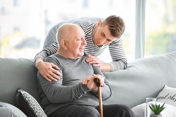 Male caregiver with senior man in nursing home - obrazy, fototapety, plakaty