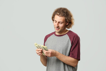 Handsome man with money on grey background