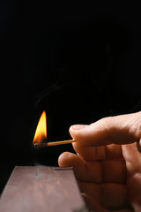 Man striking match on dark background
