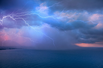 Calm tropical blue sea under amazing storm clouds with lightning 