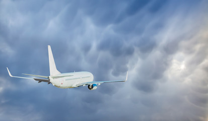 White passenger airplane in the clouds - Travel by air transport