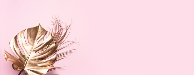 Floral minimal style concept. Exotic summer trend. Golden tropical palm monstera leaf on pastel pink color background. Shiny and sparkle design, fashion concept. © jchizhe
