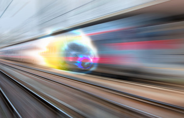 White high speed train runs on rail tracks . Train in motion