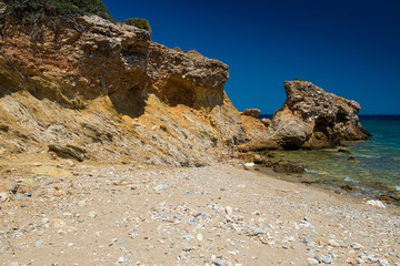 Fototapeta na wymiar Rocky coast. Beach in Greece. Wild non-tourist routes for outdoor recreation. Time to relax