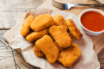 chicken nuggets with tomato sauce on wooden background. Copy space.