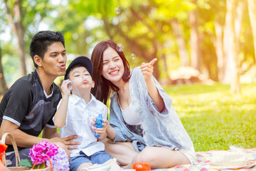 Asian Family Enjoying Playing Bubble Together in Green Park Natural outdoor background