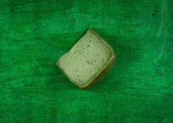 piece of green pesto cheese on a green background
