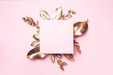 Golden leaves on pink background with copy space. Top view. Copy space. Summer and autumn concept....