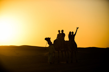 Silhouettes at sunset in the Arabian desert 
