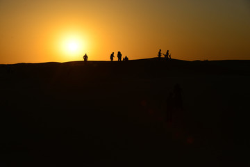 Fototapeta na wymiar Silhouettes at sunset in the Arabian desert 