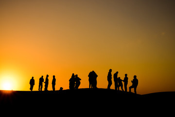 Fototapeta na wymiar Silhouettes at sunset in the Arabian desert 