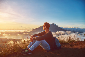 Man enjoying nice landscape from a top of mountain Batur, Bali, Indonesia.