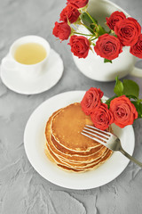 Independence Day on July 4th, American pancakes on the table next to the crockery and red roses.