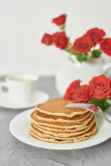 Independence Day on July 4th, American pancakes on the table next to the crockery and red roses.