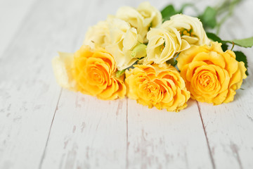 Yellow Roses for Mother's Day on a white wooden background.