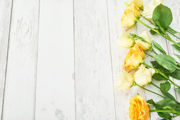 Yellow Roses for Mother's Day on a white wooden background.