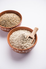 Bajra (pearl millet) / sorghum grains with it's flour or powder in a bowl, selective focus