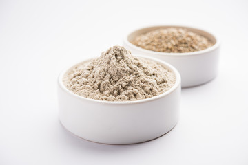 Bajra (pearl millet) / sorghum grains with it's flour or powder in a bowl, selective focus