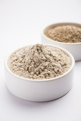 Bajra (pearl millet) / sorghum grains with it's flour or powder in a bowl, selective focus
