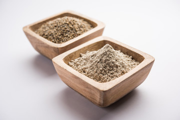 Bajra (pearl millet) / sorghum grains with it's flour or powder in a bowl, selective focus