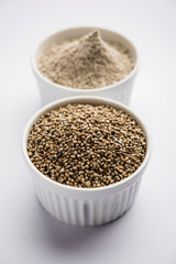 Bajra (pearl millet) / sorghum grains with it's flour or powder in a bowl, selective focus