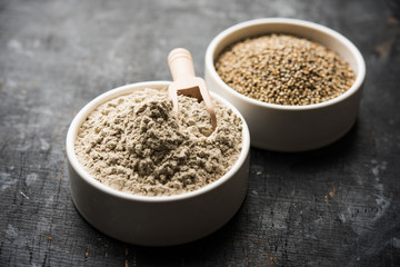 Bajra (pearl millet) / sorghum grains with it's flour or powder in a bowl, selective focus