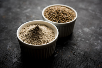 Bajra (pearl millet) / sorghum grains with it's flour or powder in a bowl, selective focus