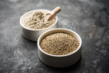 Bajra (pearl millet) / sorghum grains with it's flour or powder in a bowl, selective focus