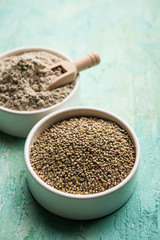 Bajra (pearl millet) / sorghum grains with it's flour or powder in a bowl, selective focus