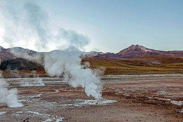 Hot spring at El Tatio Geysers with steaming geysers, hot springs, boiling water all around at sunrise, Chile, South America