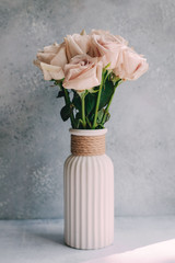 soft pink roses in vase on grey and blue back. Background