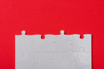 top view of connected white jigsaw puzzle pieces isolated on red