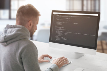 The guy programming on a computer in the office.