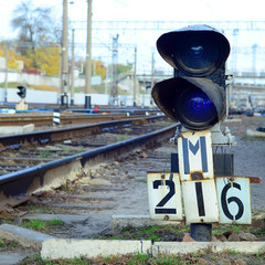 Semaphore with burning blue light. The intersection of railway tracks
