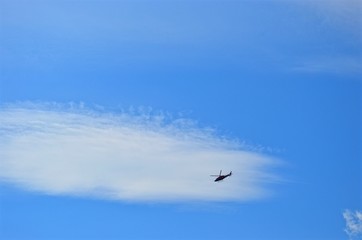 flying on the background of clouds and blue sky helicopter