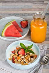 Breakfast. Muesli with milk or yogurt, nuts and strawberries, orange juice and watermelon.