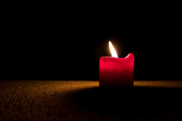 Kerze auf Grabstein in Dunkelheit