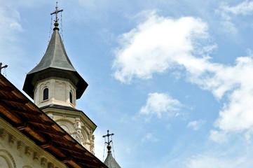 Bottom view of church turrets with crosses on cloudy sky background.
