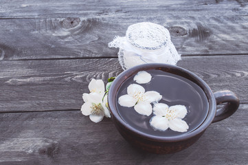 Obraz na płótnie Canvas Jasmine tea with jasmine flowers on a dark background