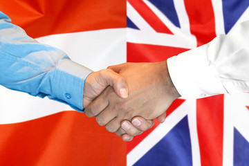 Business handshake on the background of two flags. Men handshake on the background of the Austria and United Kingdom flag. Support concept