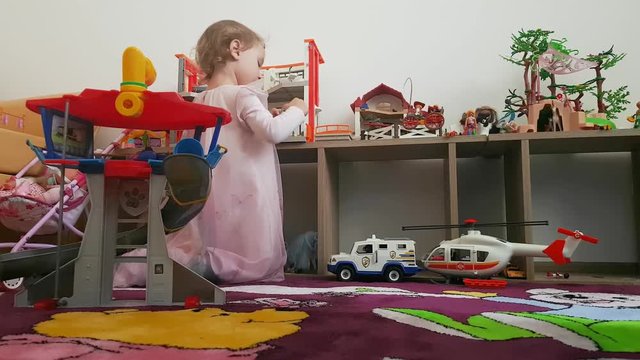 Little girl plays with her toys in her room unaware of the camera. Childhood moments