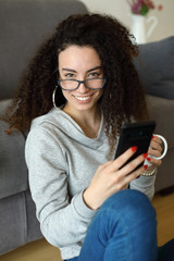 Relaxed casual girl texting on smartphone at home