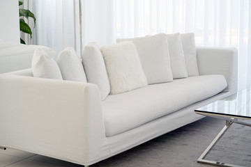 Interior of the living room of the hotel. Beautiful living room with white sofa. White Concept Living Room Interior. Modern bedroom interior in Luxury villa. White colours, big window