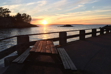 Sonnenuntergang am Vättern See in Schweden mit Sitzgruppe im Vordergrund - Sunset at Lake Vättern in Sweden with seating in the foreground